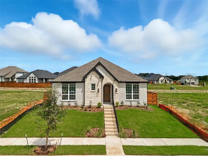 French country home with stone siding and roof with shingles