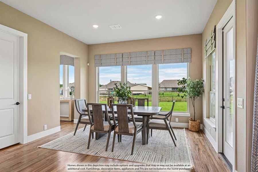Dining room with dark wood table and chairs, hardwood floors, and large windows overlooking a backyard Dining room with dark wood table and chairs, hardwood floors, and large windows overlooking a backyard