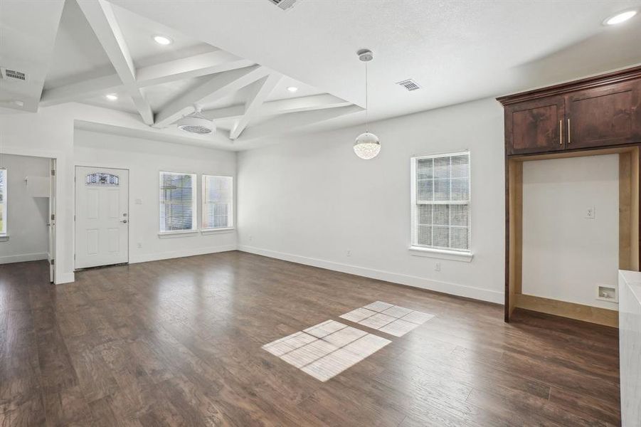 Unfurnished living room with beam ceiling, dark hardwood / wood-style flooring, and coffered ceiling