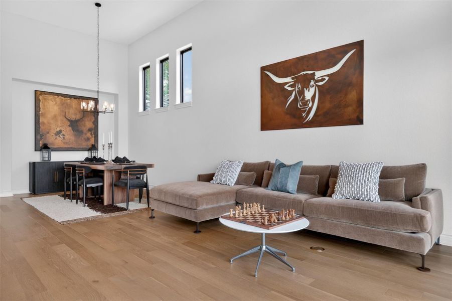 Hardwood floors stretch across this inviting living and dining space, bathed in natural light from tall, narrow windows. Hardwood floors stretch across this inviting living and dining space, bathed in natural light from tall, narrow windows.