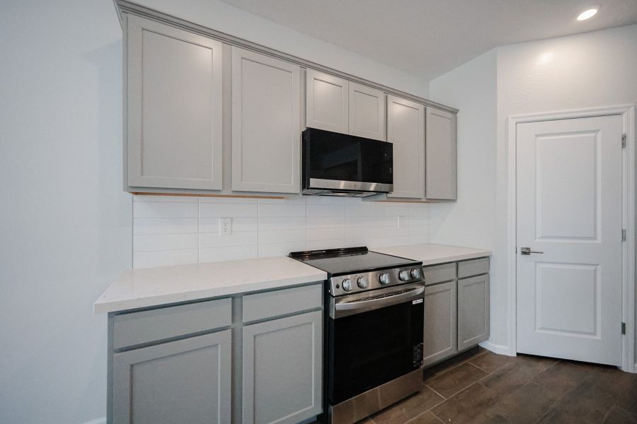 A kitchen with white cabinets.