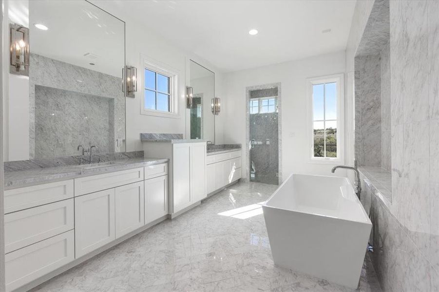 Luxurious and marble appointed with free standing soaking tub, separate show and double vanities with storage galore, huge walk in closet adjacent with built in dressers and stainless rods. Shelves and built in mirror.
