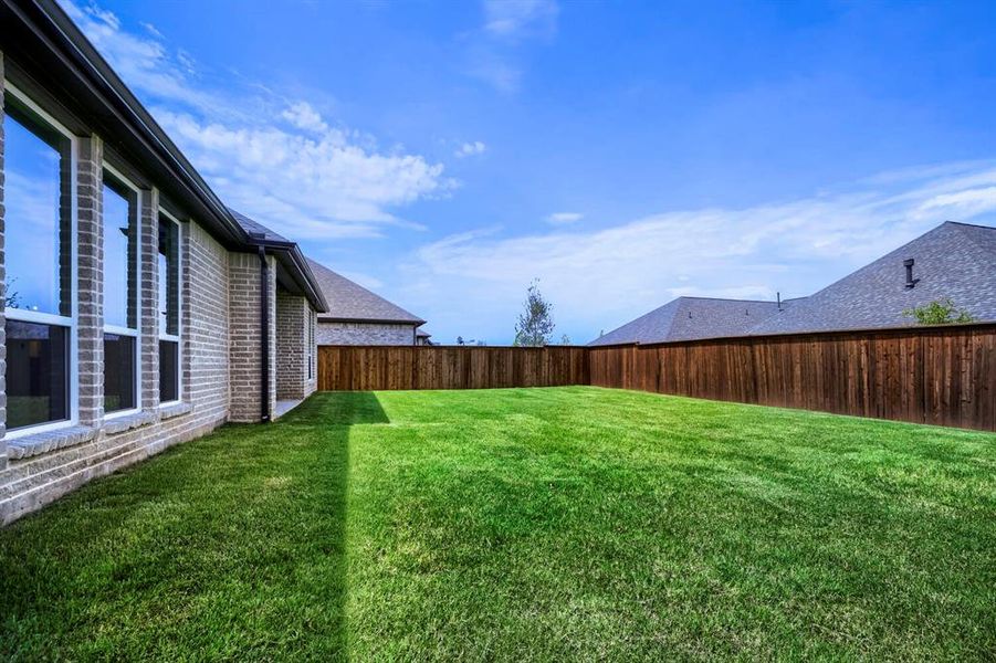 Spacious fenced backyard with a manicured lawn Spacious fenced backyard with a manicured lawn