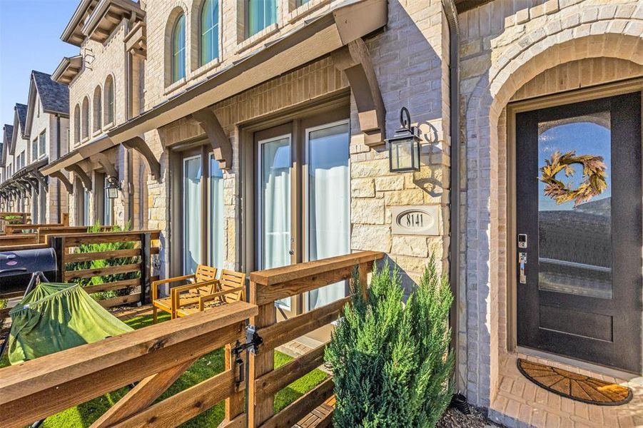 Entrance to property featuring stone siding and brick siding