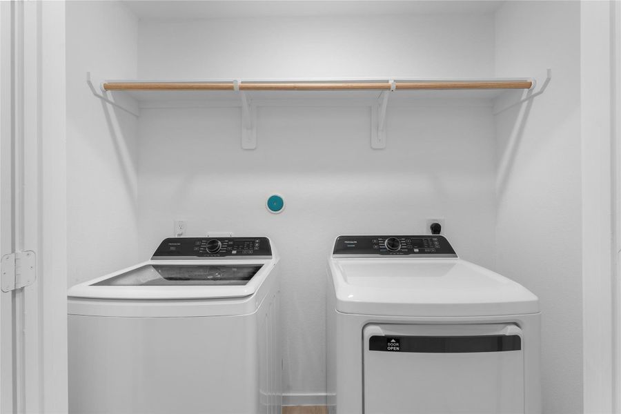 Washer and dryer included, with overhead storage keeping laundry essentials within easy reach.