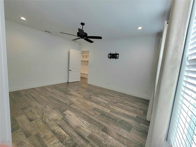 Master bedroom featuring crown molding, ceiling fan, and dark wood-type flooring