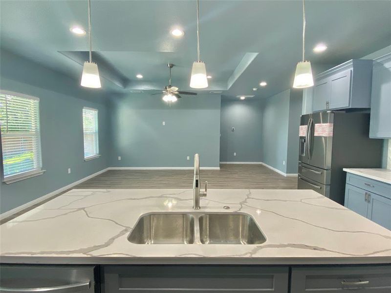 A well-lit kitchen with sleek countertops and modern appliances seamlessly connects to an open living area. A well-lit kitchen with sleek countertops and modern appliances seamlessly connects to an open living area.