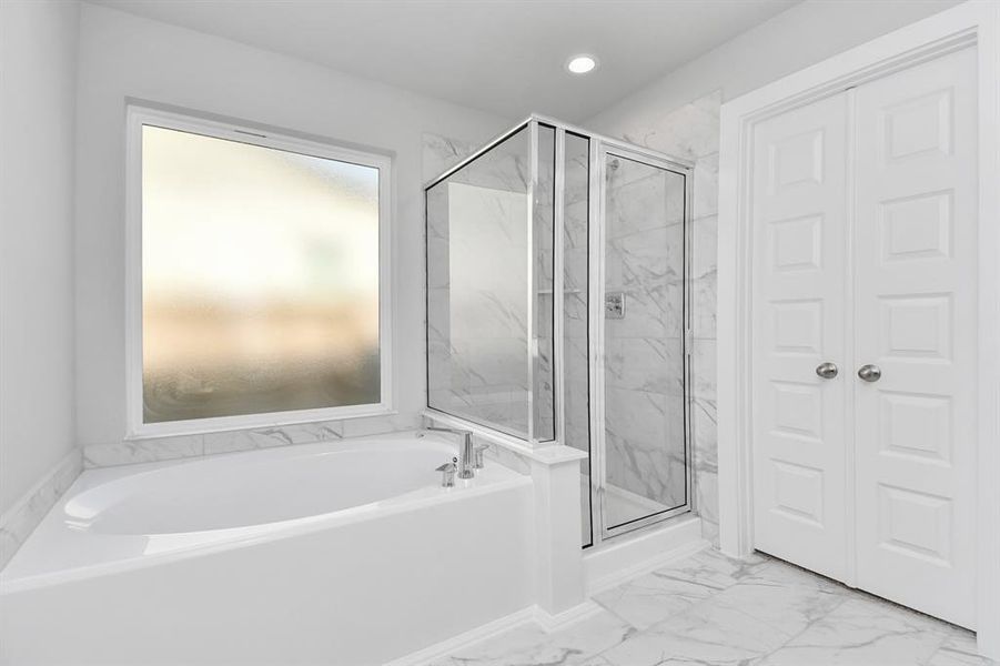 This additional view of the primary bath features a walk-in shower with the tile surround and separate garden tub perfect for soaking after a long day. Representation photo. Actual colors and selections may vary.