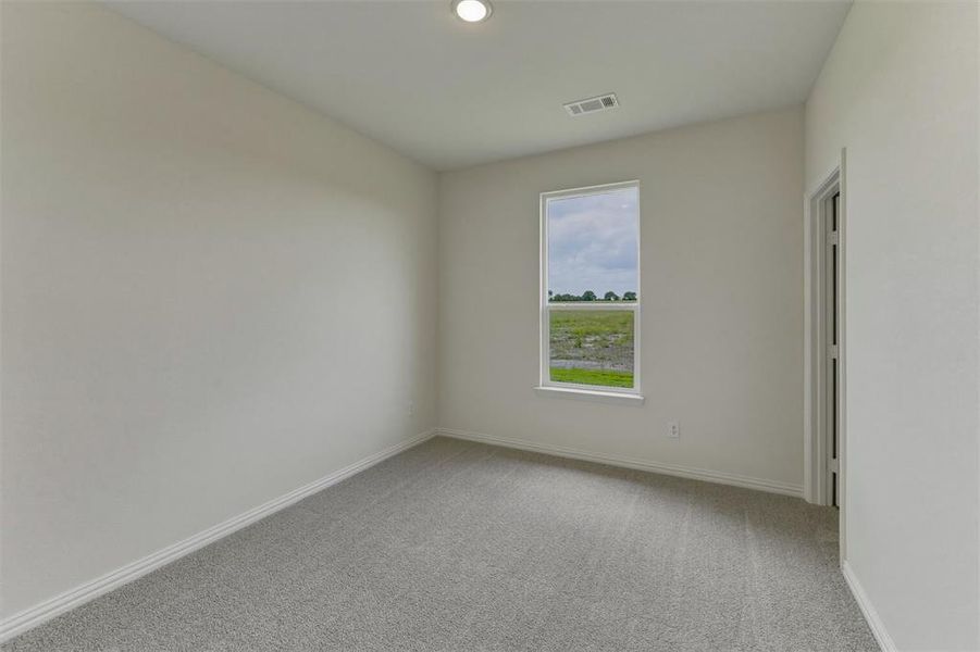 Bright interior space featuring a single window, recessed lighting, and neutral-toned carpet flooring Bright interior space featuring a single window, recessed lighting, and neutral-toned carpet flooring