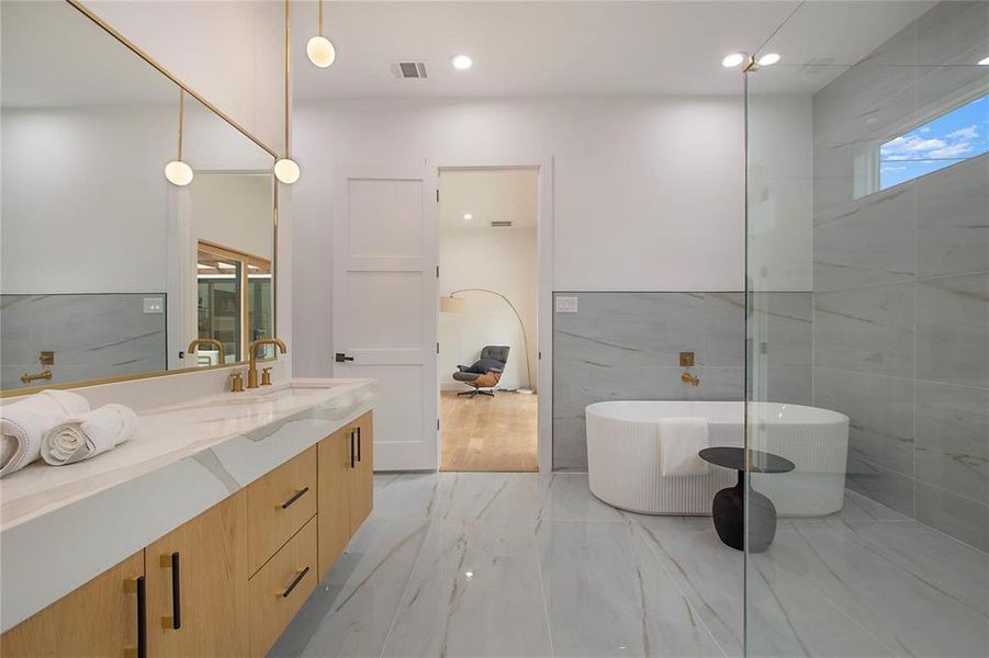 Full bathroom featuring marble look tiles, vanity, a soaking tub, tile walls, and recessed lighting Full bathroom featuring marble look tiles, vanity, a soaking tub, tile walls, and recessed lighting