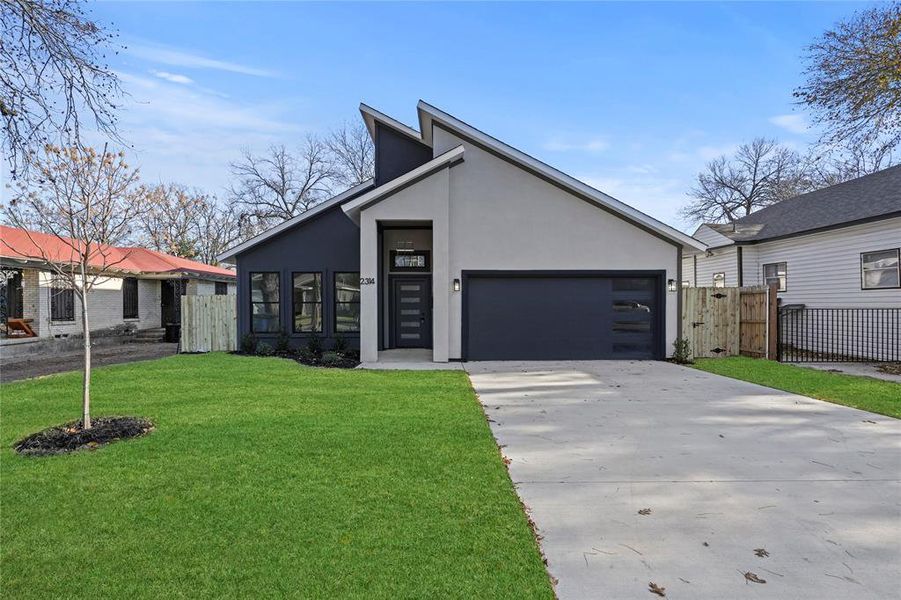 View of front facade with a front yard and a garage