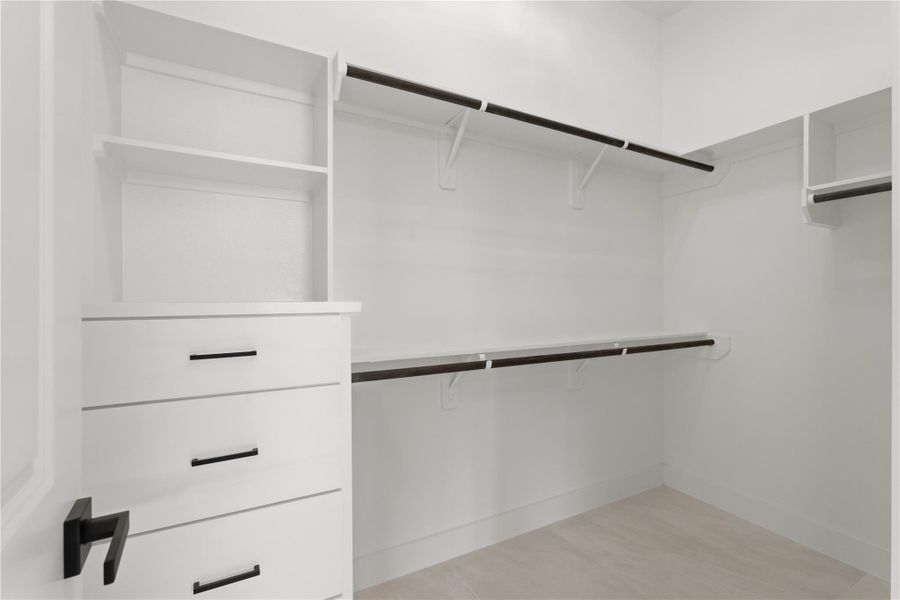In the primary suite, you’ll find a large walk-in closet with custom shelving from floor to ceiling and built-in drawers for easy organization.