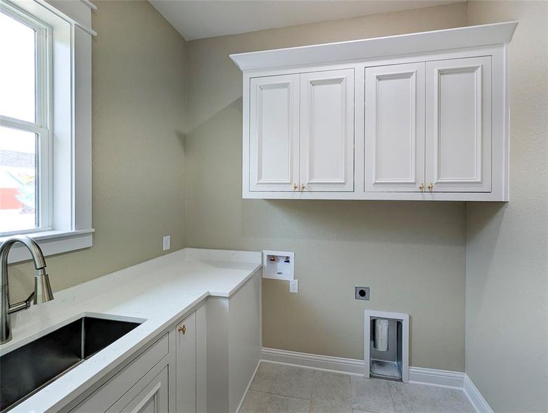 Washroom featuring hookup for a washing machine, hookup for an electric dryer, cabinet space, and light tile patterned flooring