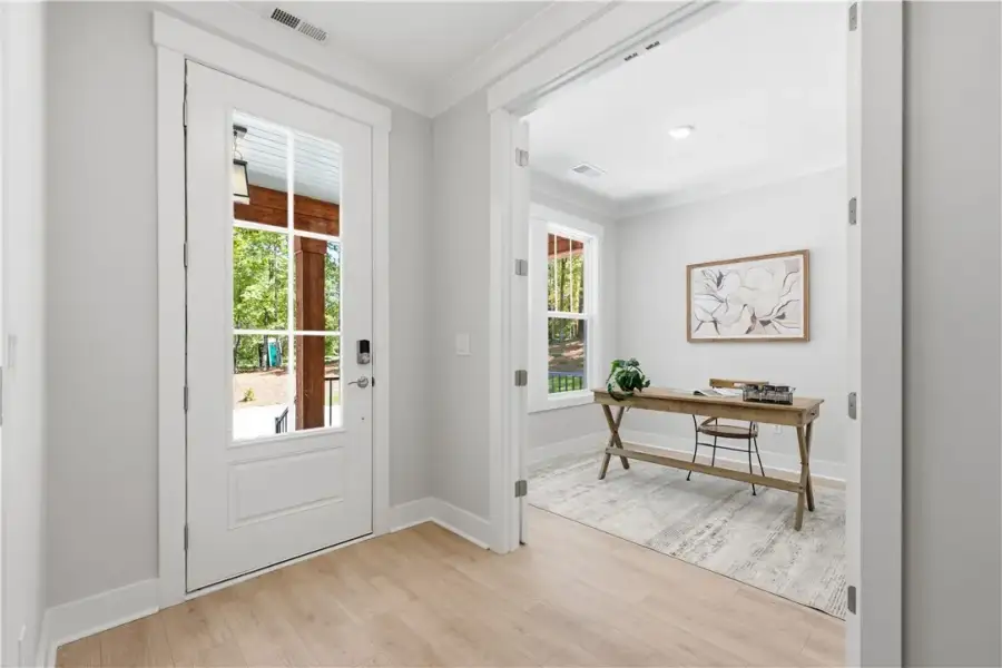 Natural light streams through the glass entry door