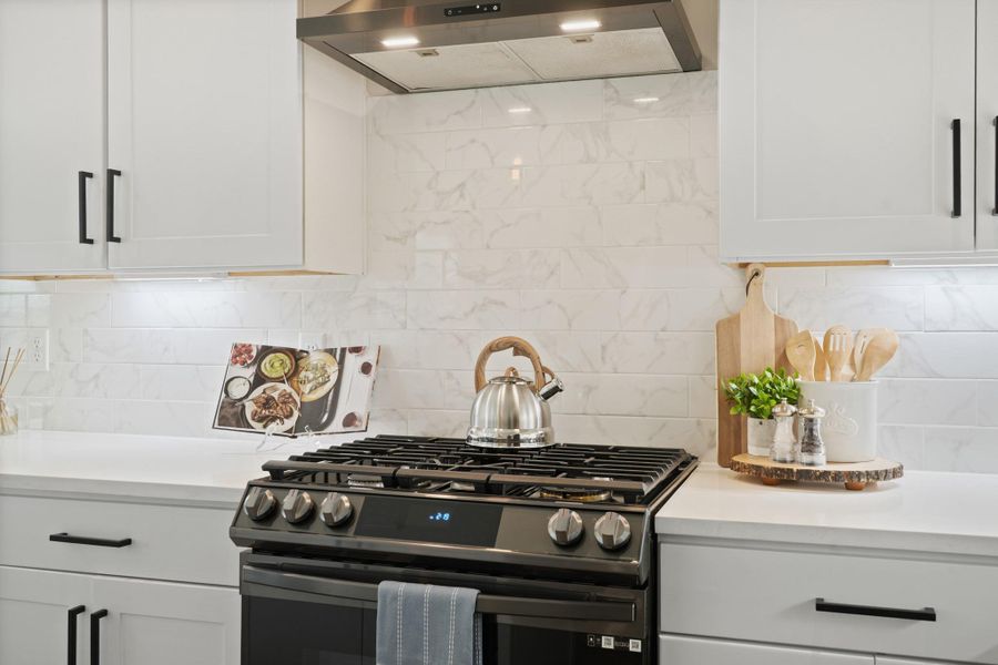 The kitchen comes equipped with a full suite of Samsung appliances, including a five-burner gas range with built-in air fryer and Wi-Fi controls, a Zephyr vent hood, a French door refrigerator with LED front screen, a microwave and a matching Samsung dishwasher. The kitchen comes equipped with a full suite of Samsung appliances, including a five-burner gas range with built-in air fryer and Wi-Fi controls, a Zephyr vent hood, a French door refrigerator with LED front screen, a microwave and a matching Samsung dishwasher.