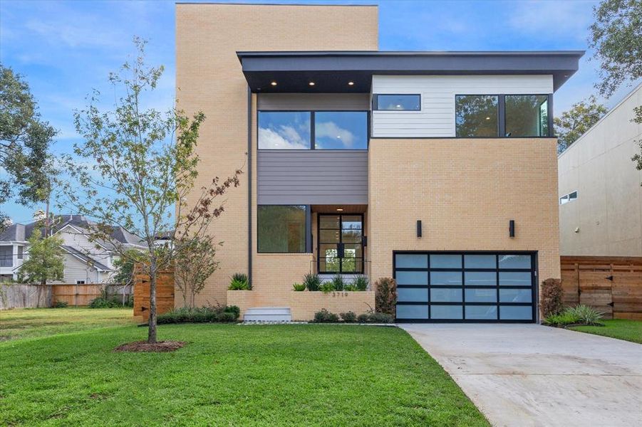 Beautiful front entry with gently ascending stairs and planters filled with lush landscaping.