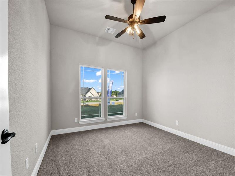 Carpeted empty room featuring ceiling fan