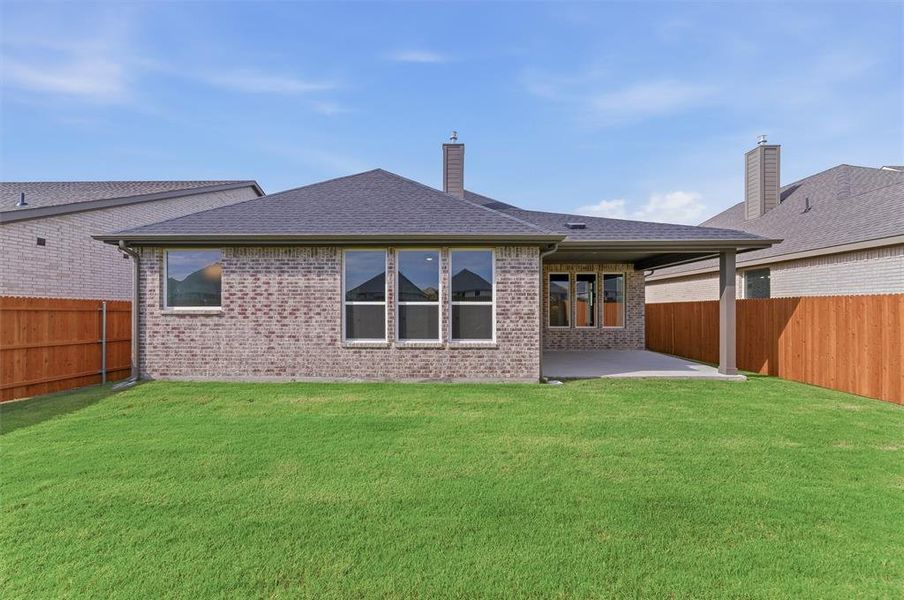 Expansive green lawn with a covered concrete patio