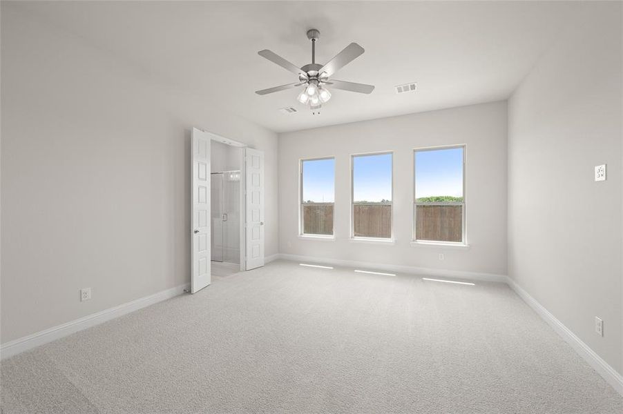 Unfurnished bedroom with light colored carpet and ceiling fan