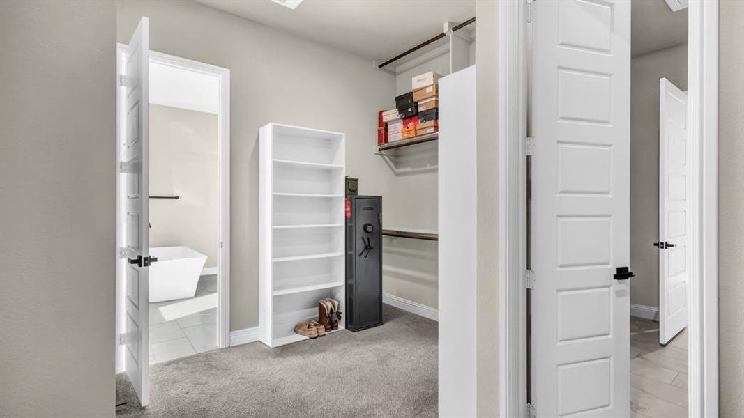 Primary bedroom closet provides custom built ins.