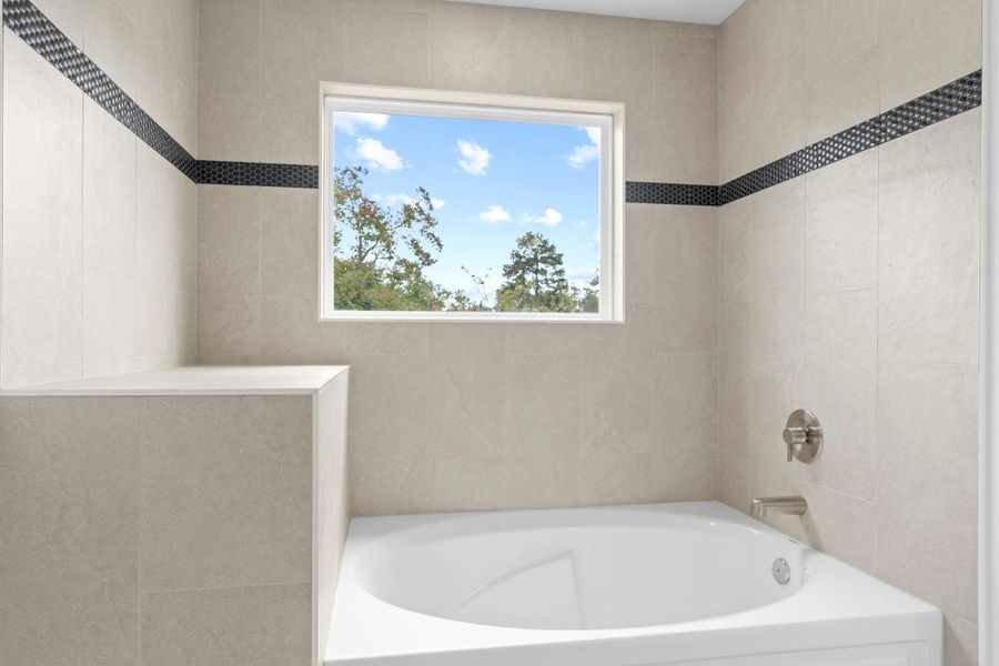 Take a look at the beautiful custom details in this primary spa bathroom. The deep soaker tub is perfect for melting the stress away, and the elegant built-in shelf adds the ideal spot for towels and décor to elevate your bath time. Even the chic faucet adds a stylish finishing touch to this luxurious retreat. Take a look at the beautiful custom details in this primary spa bathroom. The deep soaker tub is perfect for melting the stress away, and the elegant built-in shelf adds the ideal spot for towels and décor to elevate your bath time. Even the chic faucet adds a stylish finishing touch to this luxurious retreat.