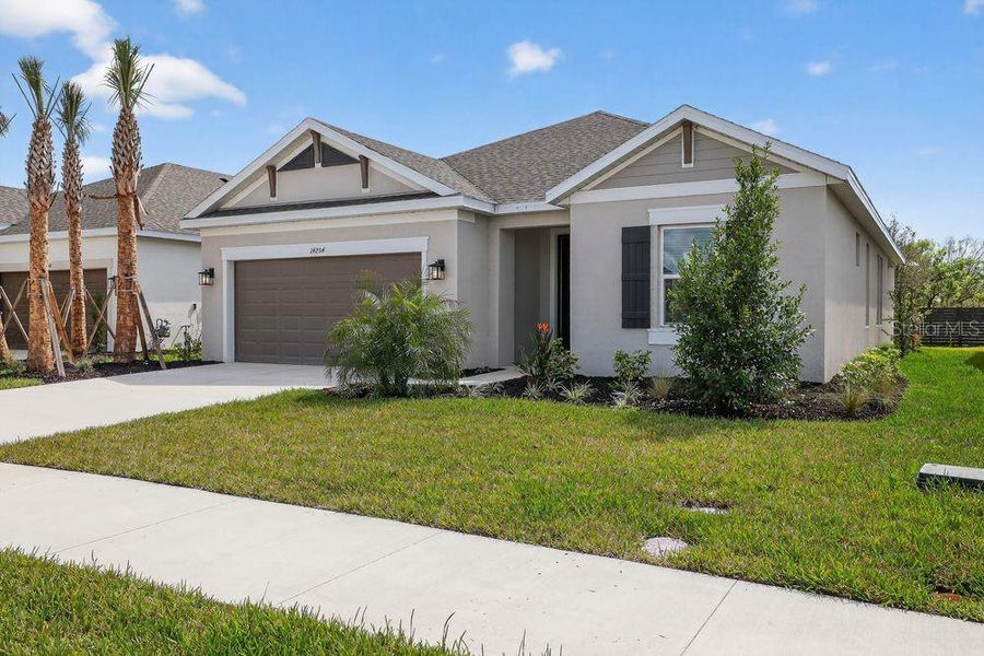 Front exterior of a new home in Firethorn, Parrish, FL, highlighting curb appeal (Image 21).