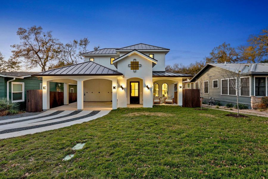 View of front of house featuring a standing seam roof, a metal roof, stucco siding, and a patio area View of front of house featuring a standing seam roof, a metal roof, stucco siding, and a patio area