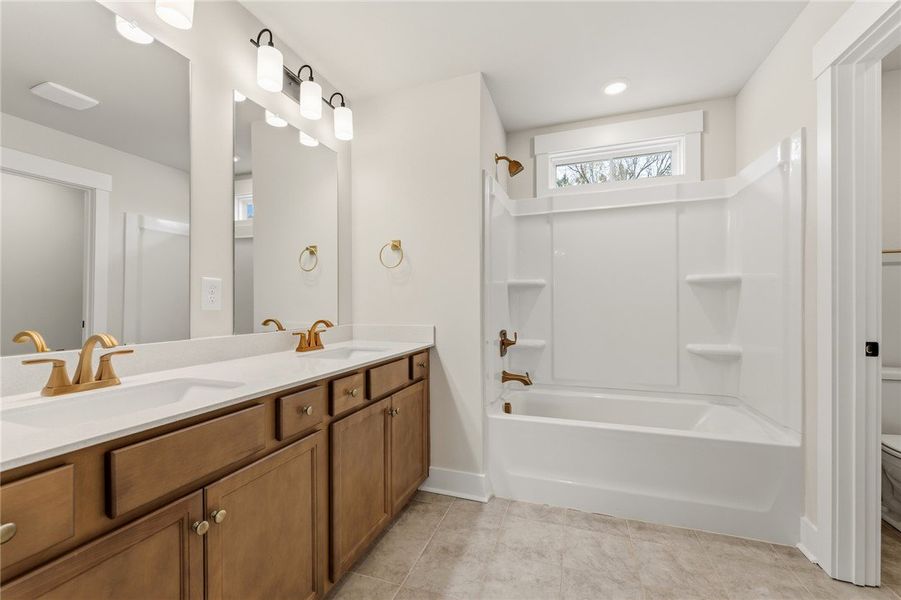 This bathroom features a double vanity and a batht