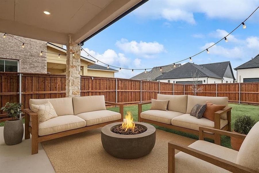 Fenced backyard with an outdoor living space with a fire pit and a patio Virtually staged