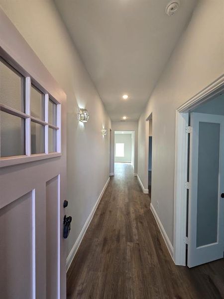 Corridor with dark wood finished floors and recessed lighting