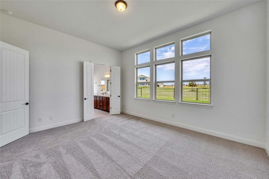 Unfurnished bedroom with light carpet and connected bathroom Unfurnished bedroom with light carpet and connected bathroom