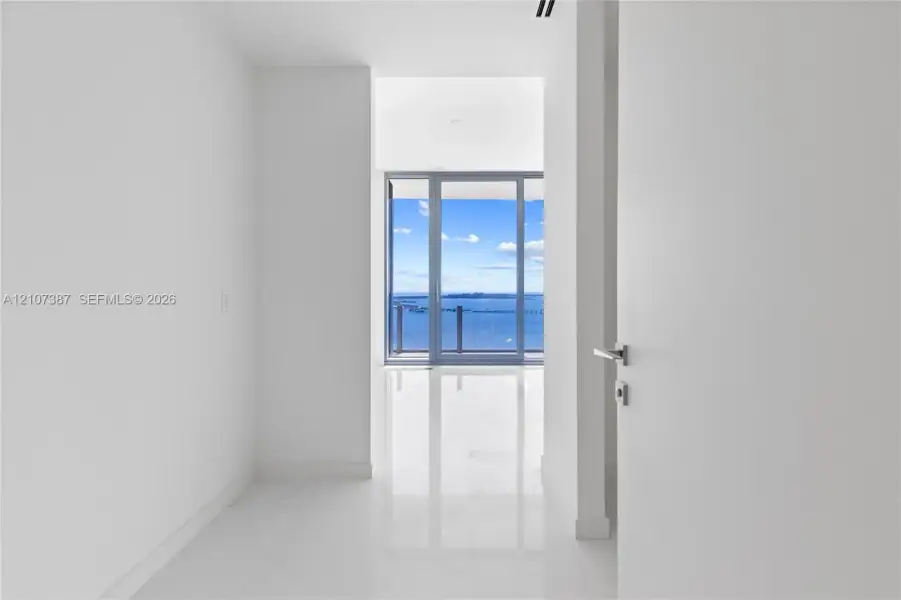 Polished stone flooring, floor-to-ceiling glass paneling, and expansive water scenery