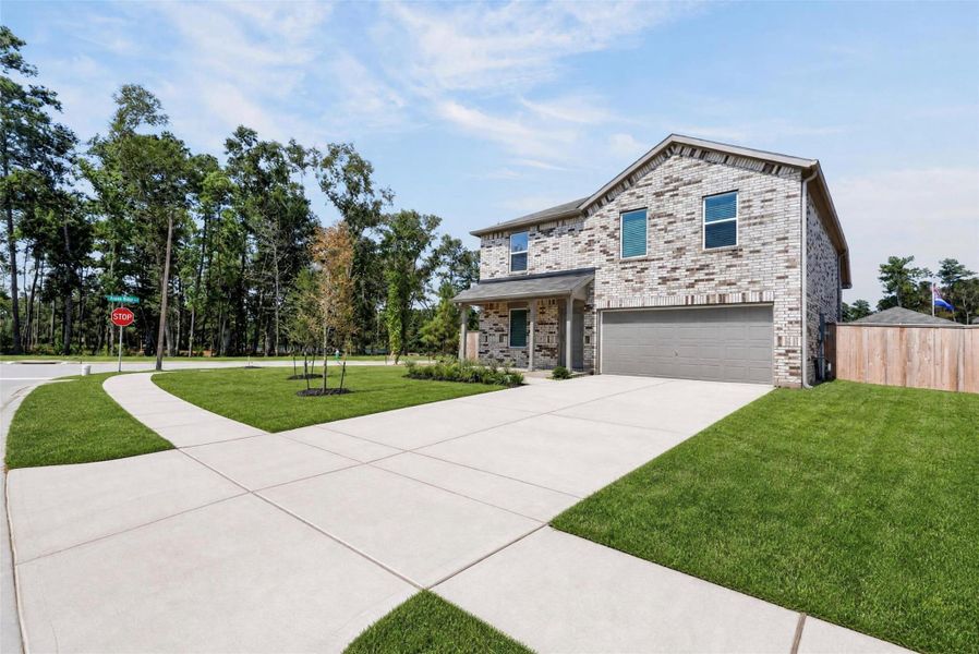 A generous driveway and beautifully maintained lawn welcome you home.