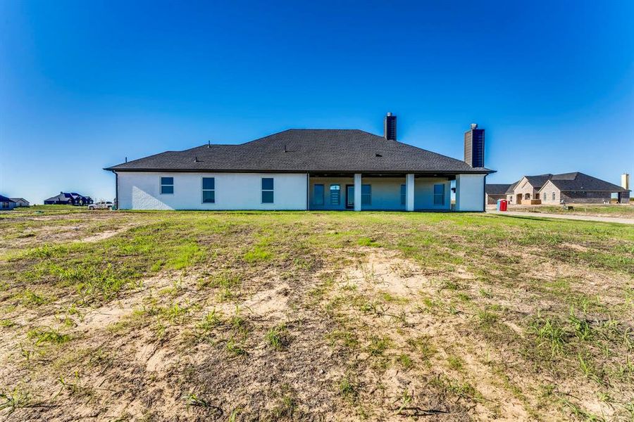 Rear view of property featuring a lawn