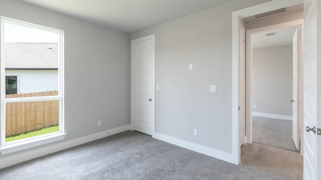 Unfurnished bedroom featuring carpet and multiple windows