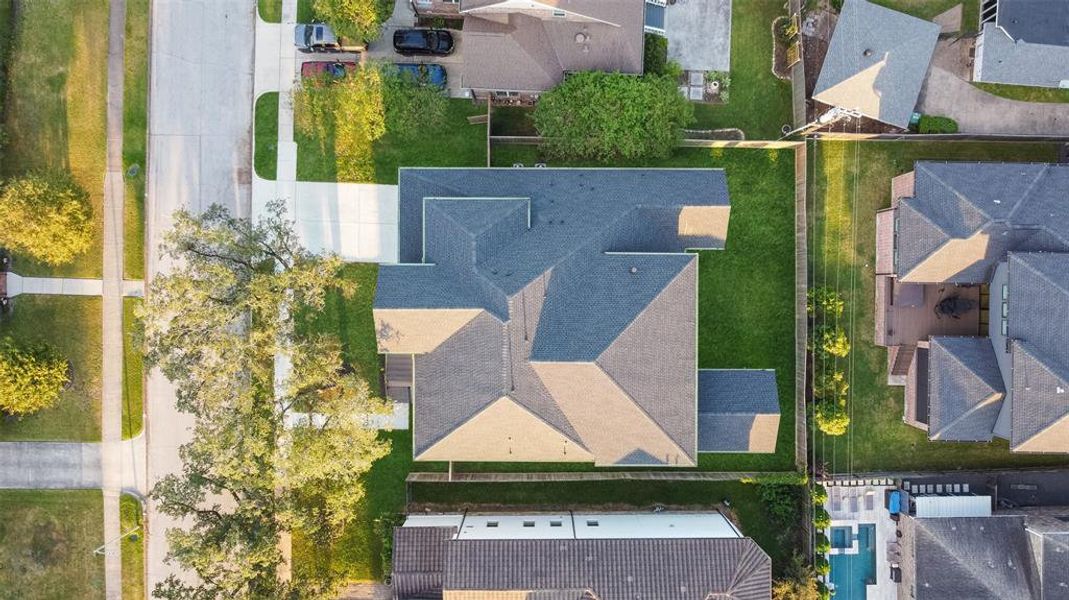 This areal image highlights the ample space in the backyard for pool or play set and the double wide driveway leading to the oversized garage.