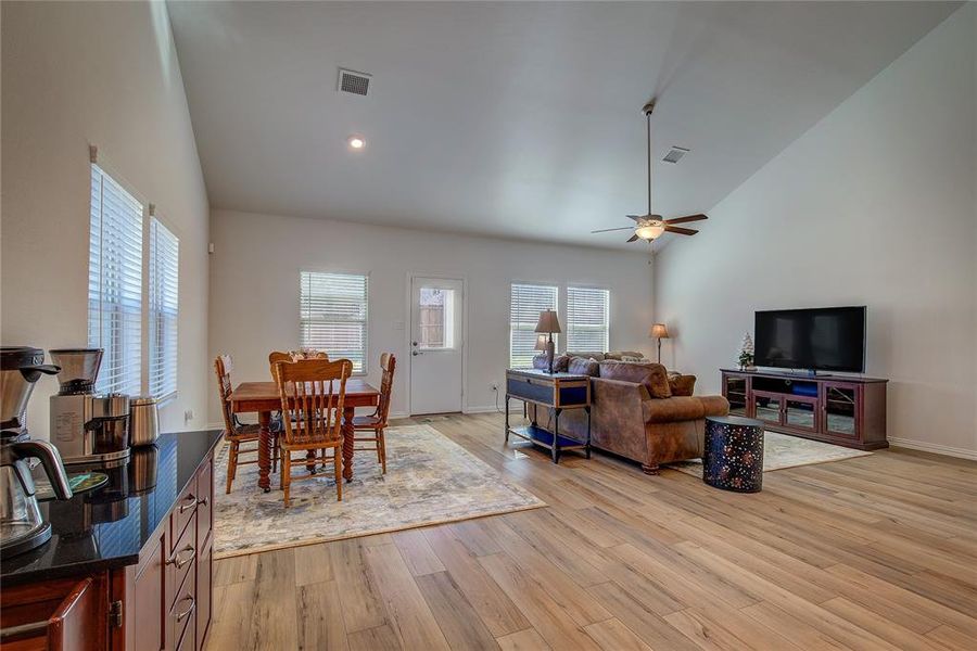 Dining area featuring ceiling fan, light hardwood / wood-style flooring, and high vaulted ceiling