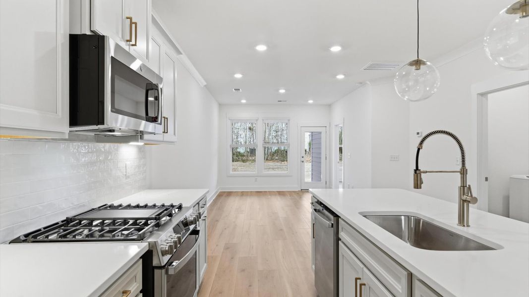 Highly skilled craftsmanship shines in this modern kitchen with pendant lighting and a central island focal point