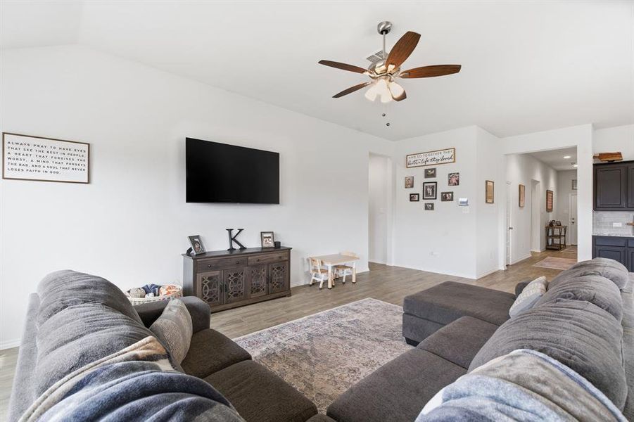 Living area with light wood-style flooring and a ceiling fan