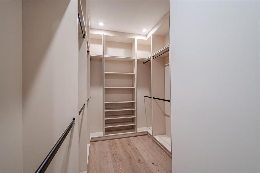 Walk in closet featuring light wood-style flooring Walk in closet featuring light wood-style flooring