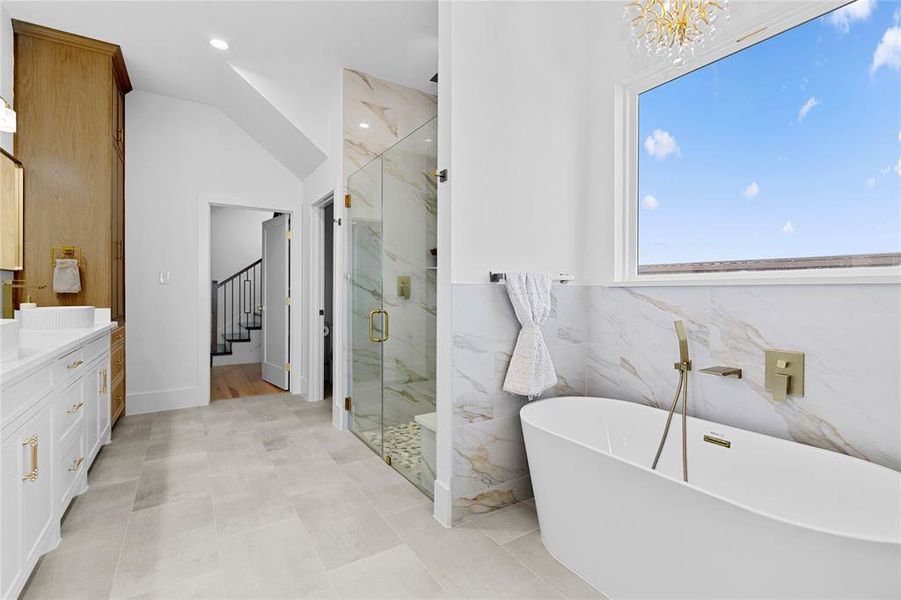 Full bath with vanity, a marble finish shower, a freestanding tub, vaulted ceiling, and recessed lighting Full bath with vanity, a marble finish shower, a freestanding tub, vaulted ceiling, and recessed lighting