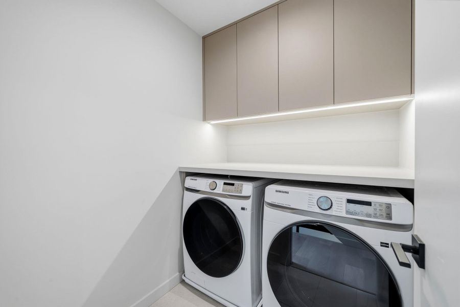 A well-appointed laundry room features modern appliances and ample storage space.