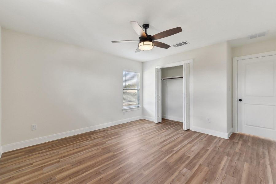 Bedroom 4 with visible vents, light wood-style flooring, and baseboards Bedroom 4 with visible vents, light wood-style flooring, and baseboards