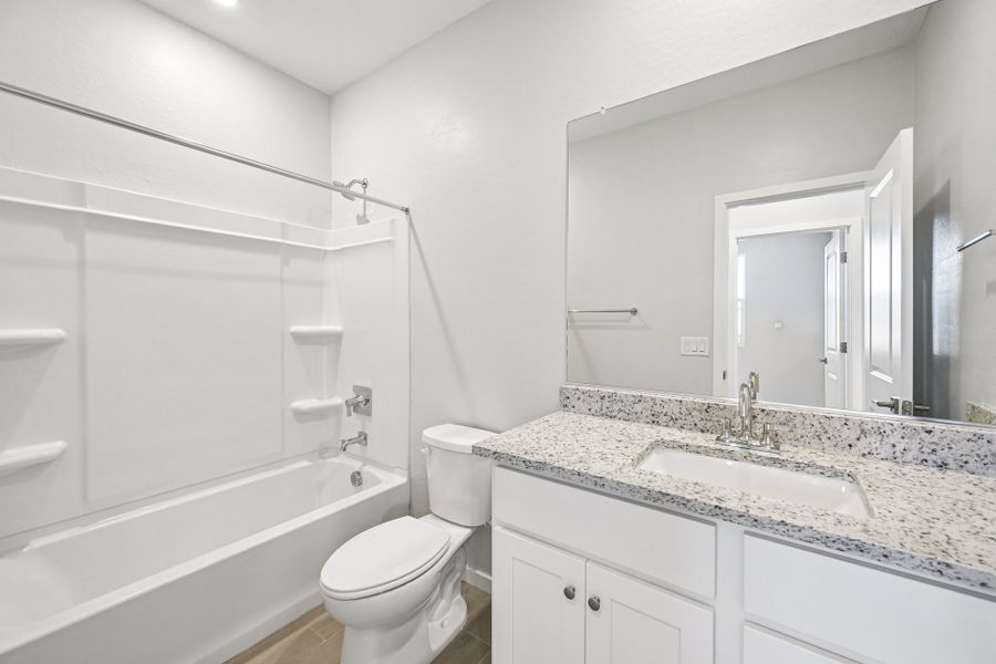A bathroom with a tub sink and toilet.