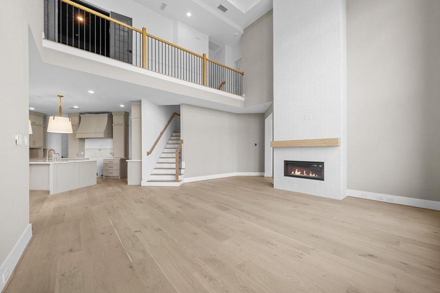 Two-story Family Room with stunning floor to ceiling stacked windows to let lots of light in with linear fireplace creating a great space to gather & entertain in off of the Kitchen, Breakfast Area, and Game Room. An additional staircase leading to the second floor is included as well. Two-story Family Room with stunning floor to ceiling stacked windows to let lots of light in with linear fireplace creating a great space to gather & entertain in off of the Kitchen, Breakfast Area, and Game Room. An additional staircase leading to the second floor is included as well.