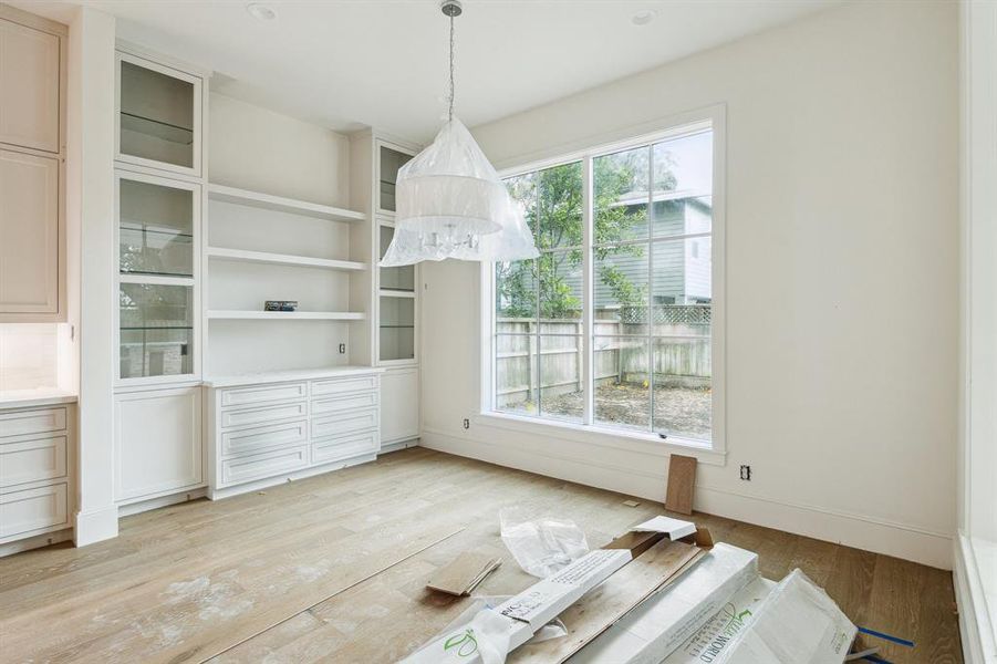 Breakfast Area with Floating Shelves, Built-In Cabinets with Glass Fronted Doors, Glass Shelves and Lighting. There are also under-counter storage drawers and storage cabinets.