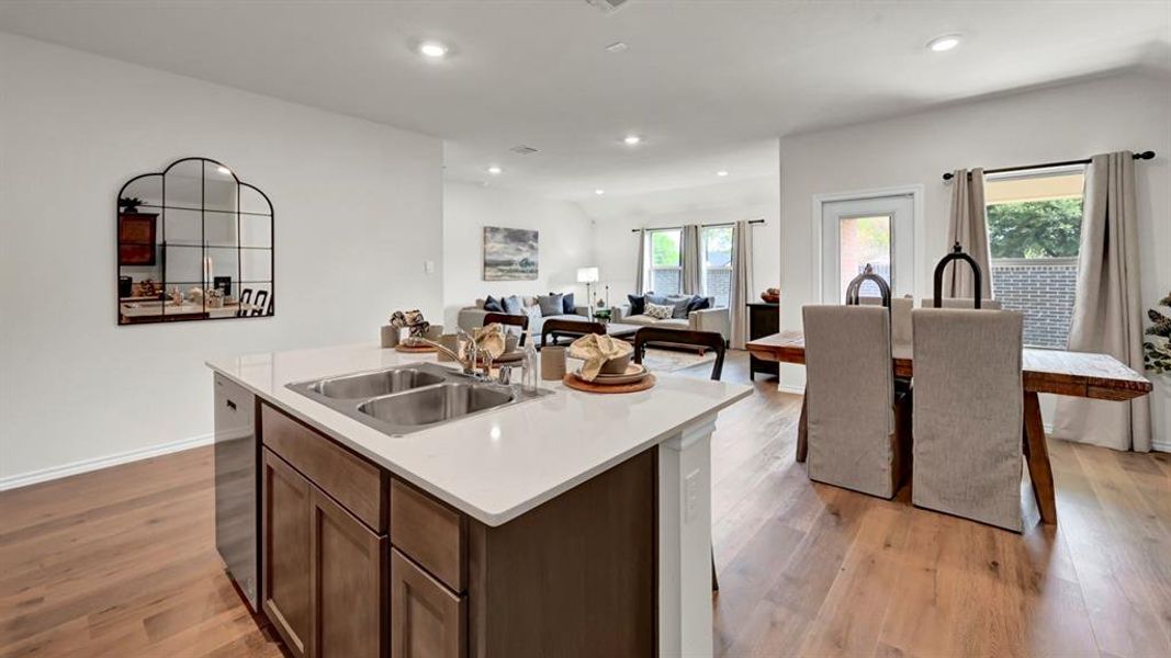 Kitchen with an island with sink, open floor plan, light wood-style floors, recessed lighting, and stainless steel dishwasher