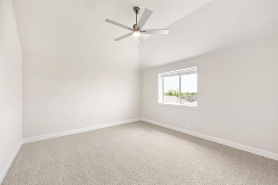 Empty bedroom with vaulted ceiling, ceiling fan, carpet flooring, and single window