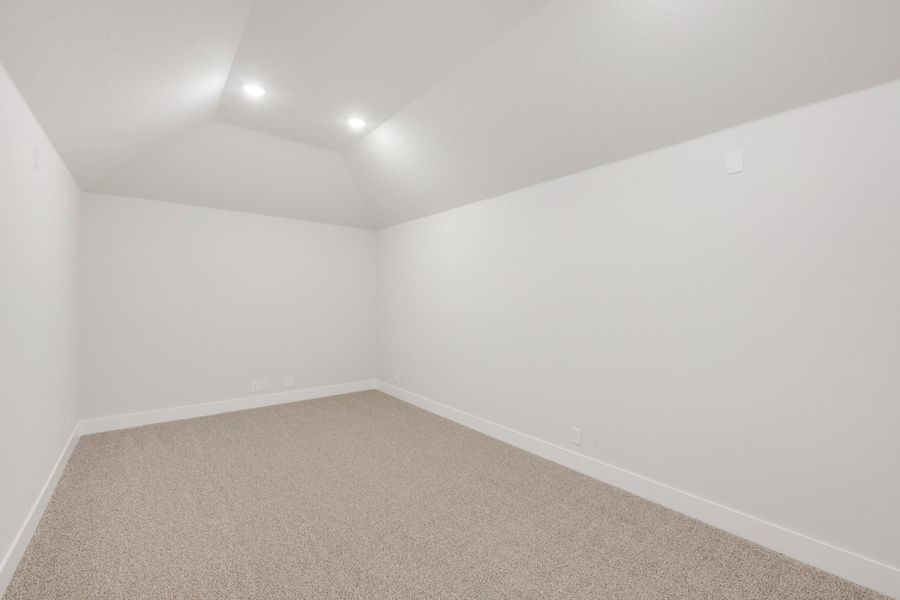 Empty room with vaulted ceiling, recessed lighting, and beige carpet on white walls