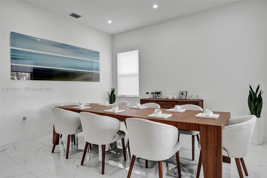 White walls and high ceilings with recessed lighting, complemented by sleek white tile flooring